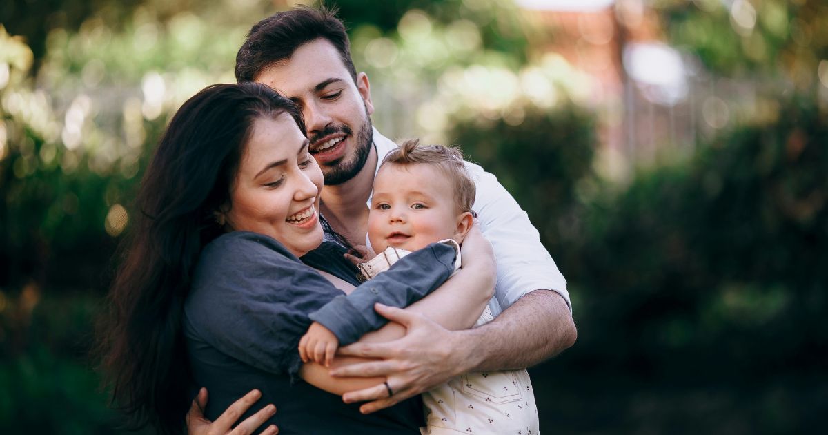 A man and women holding a baby in Bwrgen County, NJ.
