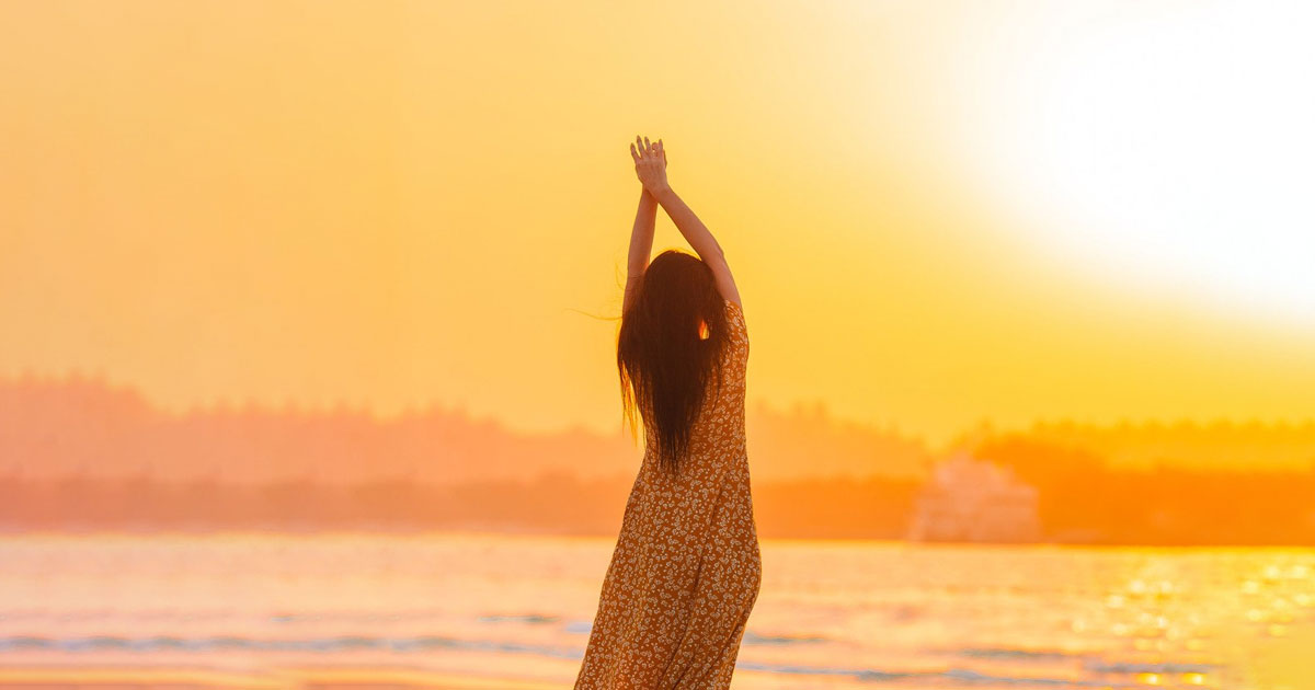 A women on beach feeling relief after getting migraine treatment in Bergen County, NJ